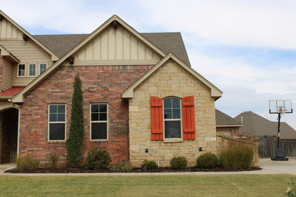 House with red brick siding, brown brick, and vertical siding